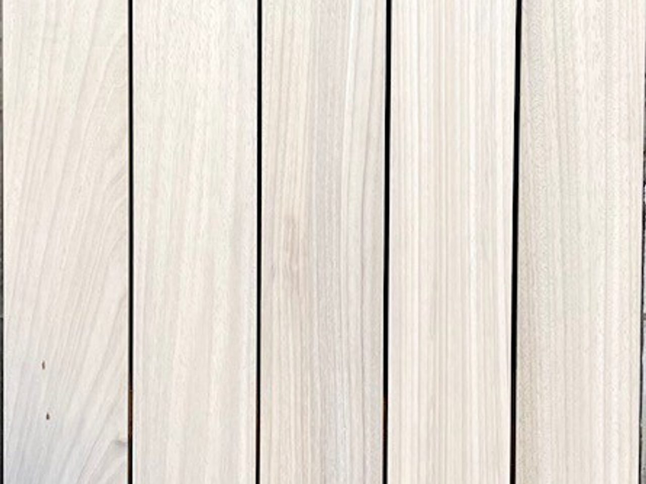 Light wooden planks run vertically with slim gaps, showing natural grain and subtle knots.