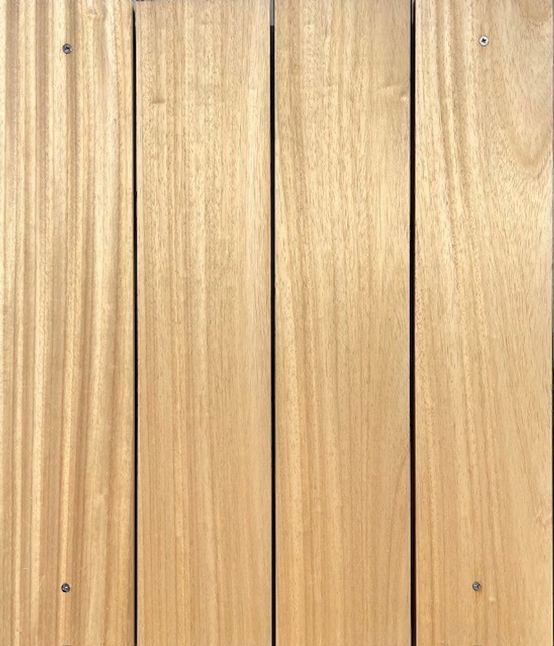 Close-up of vertical light-brown wooden planks with visible grain and small screws along the edges.