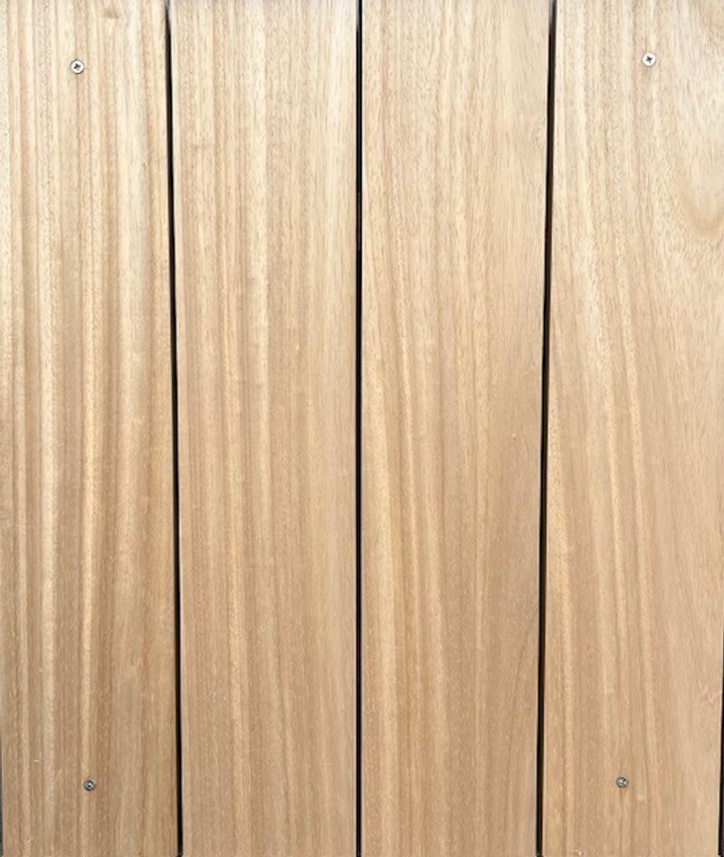 Vertical light-brown wooden boards with visible grain and small screws along the edges.