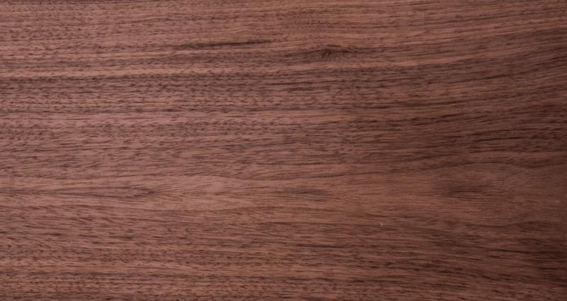 Close-up of a smooth brown wooden surface with visible grain patterns and warm tones.