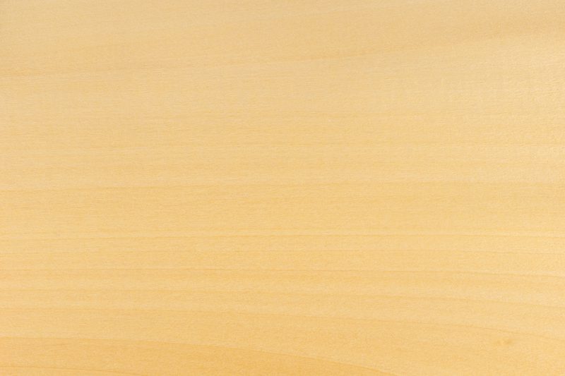 Light wooden surface with pale beige color and visible wood grain running horizontally.