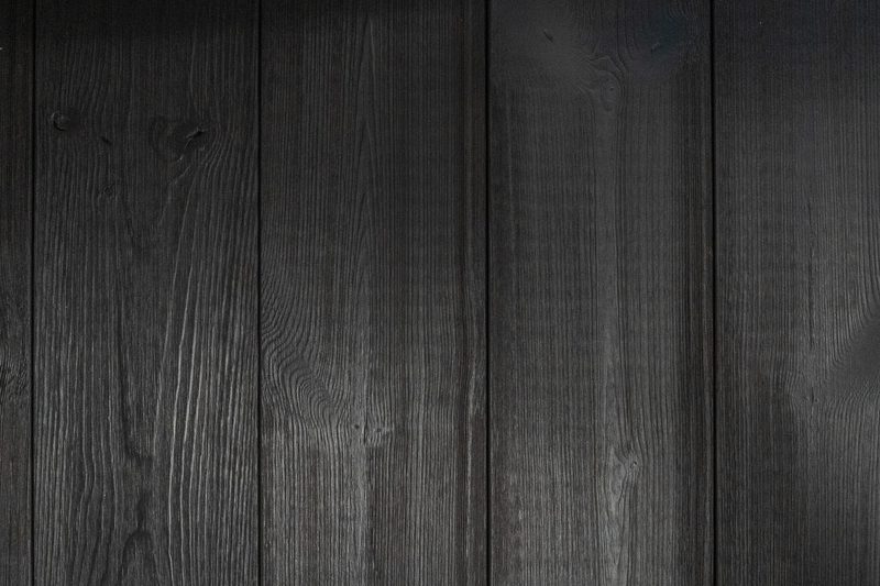Close-up view of dark, textured wooden planks with visible grain patterns.