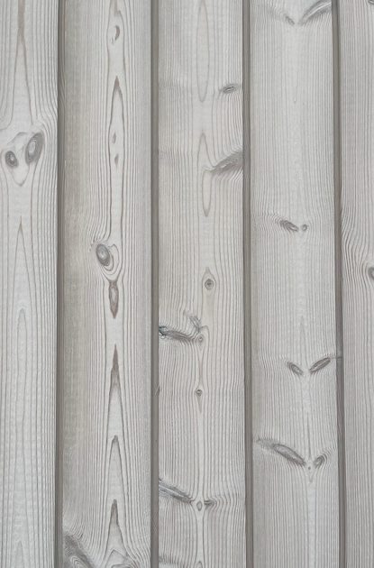 Close-up of vertical wooden planks with visible grain patterns and knots, showing a weathered gray surface.