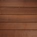 Close-up of horizontal brown wooden planks with visible grain and narrow seams, forming a warm rustic wall.