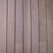 Close-up of horizontal brown wooden planks with visible grain and narrow seams, forming a warm rustic wall.