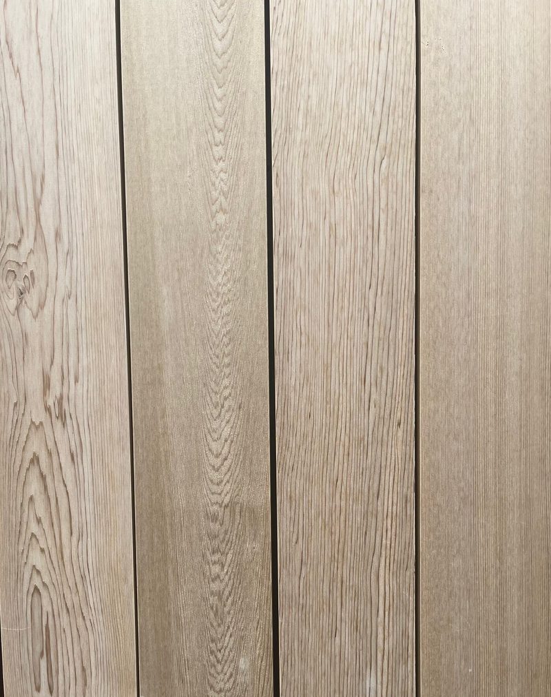 Vertical light-brown wooden planks with visible grain and narrow gaps between boards.