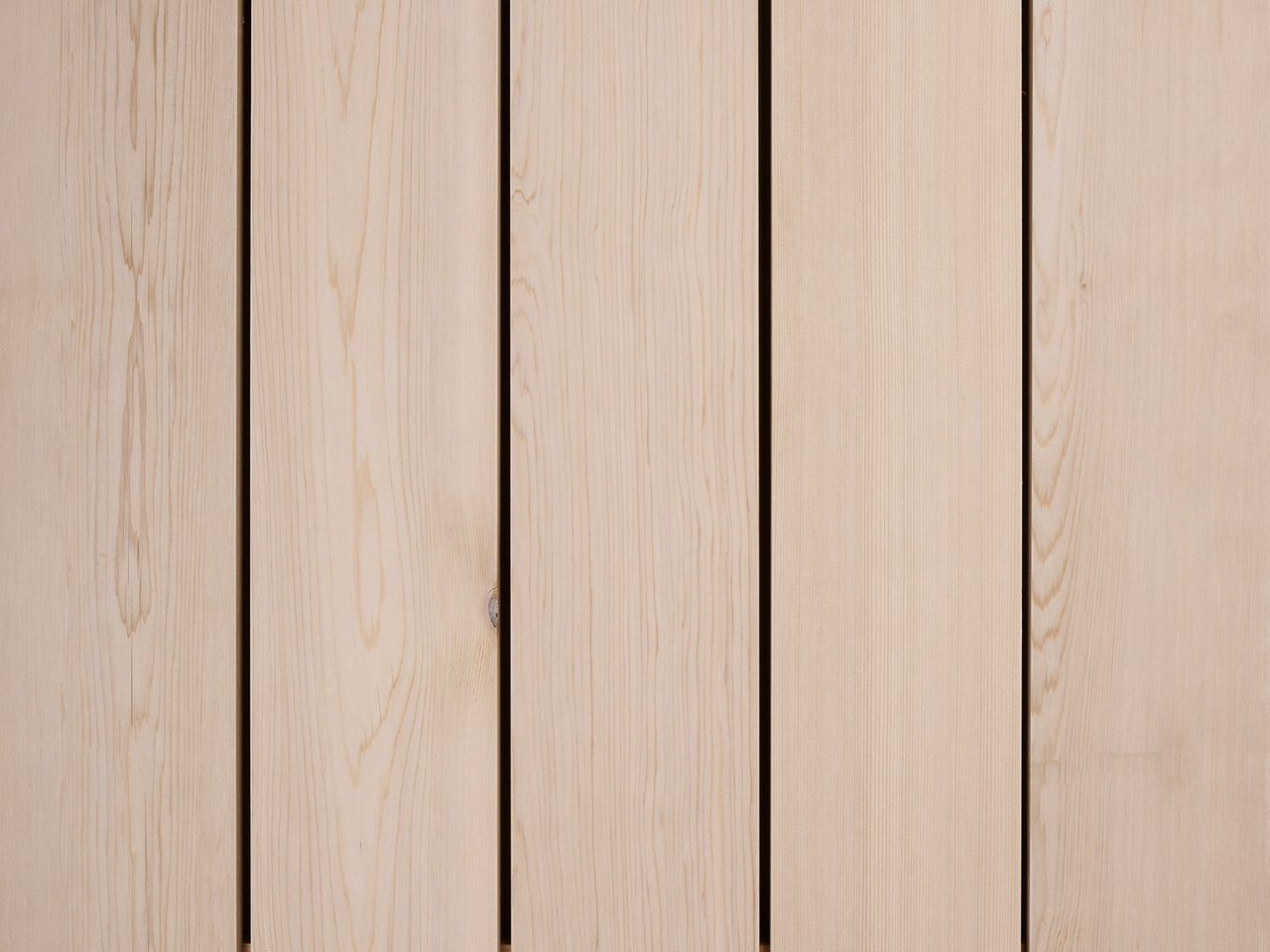 Vertical light wood planks with narrow gaps, showing natural grain and subtle knots across a wooden surface.