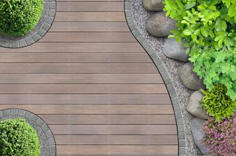 Top-down view of a curved wooden deck path edged with gray stones, with rocks and lush green shrubs on the right and round planters on the left.