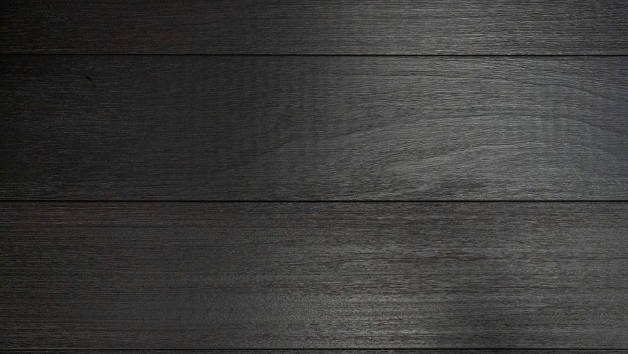 Dark wooden planks run horizontally with visible grain and a subtle gloss, forming a textured background.