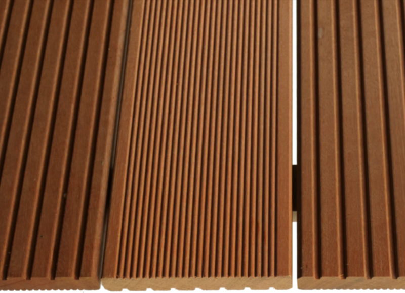 Close-up of brown wooden slats with narrow vertical grooves; a thin white gap runs between two adjacent panels on the right.