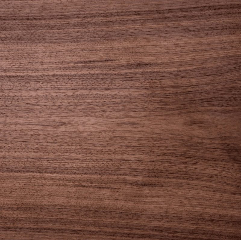 Close-up of a polished brown wood surface with visible grain lines and subtle knots running horizontally.