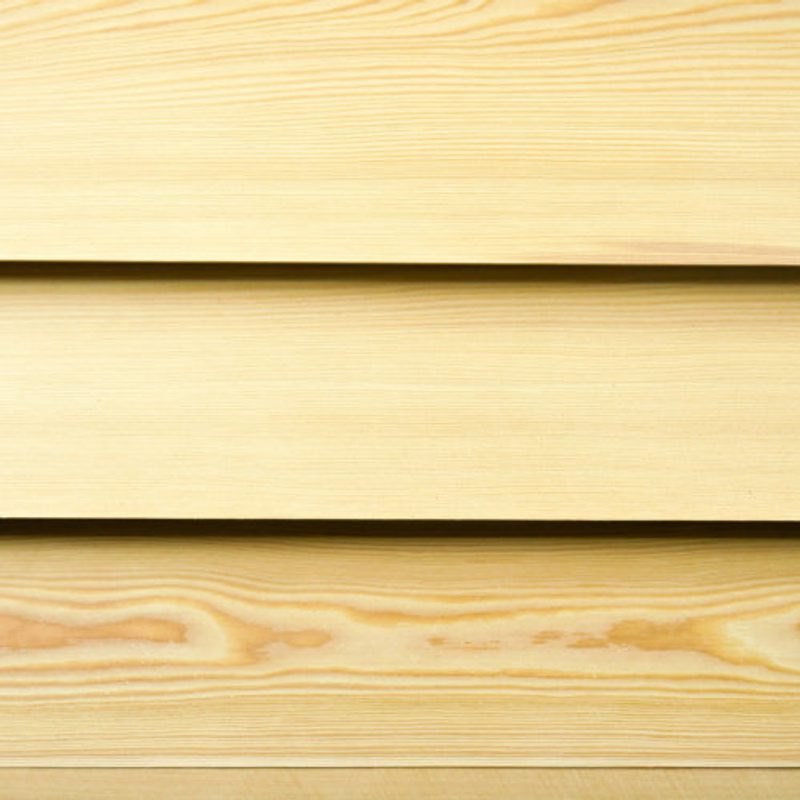 Close-up of light wood planks arranged horizontally with visible grain and narrow gaps between boards.