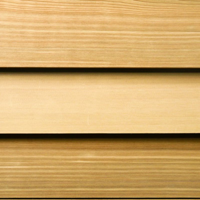 Close-up of three horizontal wooden boards in warm brown tones with visible grain and smooth surfaces.
