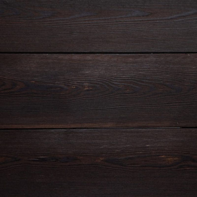 Close-up of dark brown wooden planks with visible grain and narrow gaps between boards.