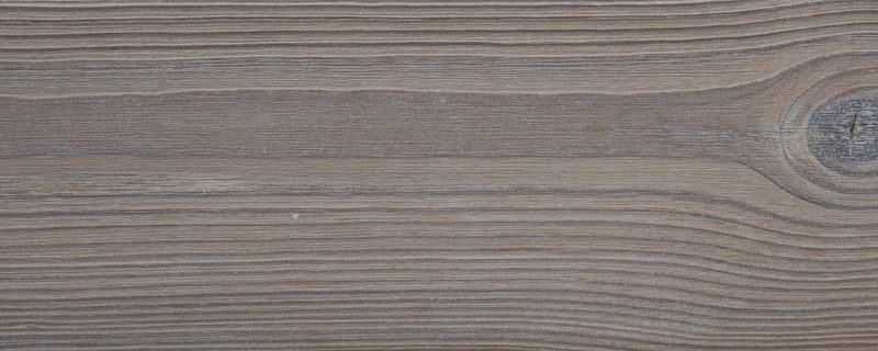 Close-up of brown wood planks with pronounced grain and a knot near the right edge.