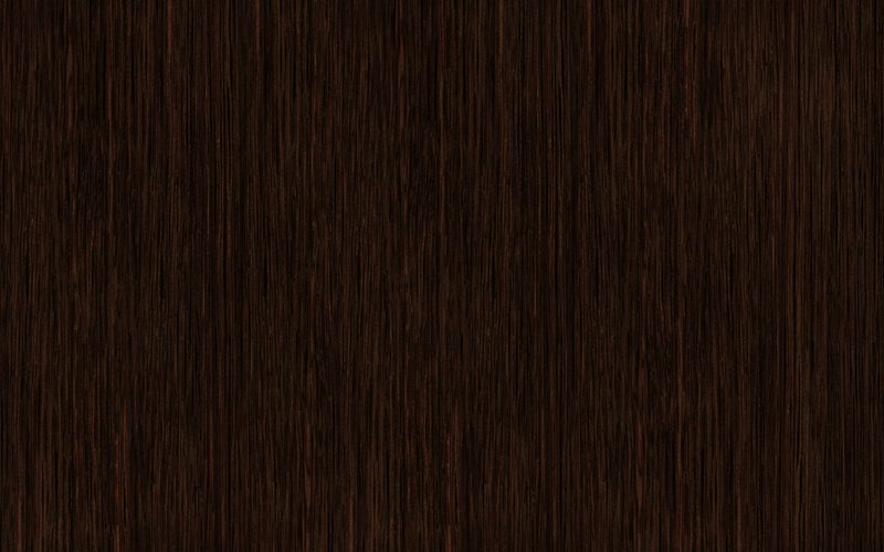 Close-up of dark brown wood with fine vertical grain and subtle color variations.