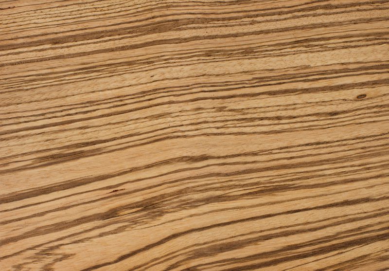 Close-up of a light wood surface with dark, wavy grain patterns running diagonally across.