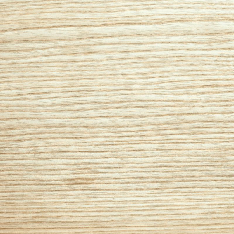 Light oak wood surface with subtle horizontal grain lines in beige and tan tones.