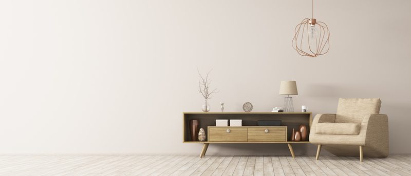 Minimalist living room with a light wood low console, beige armchair, copper wire pendant lamp, and pale wood floor; decorative items on the console.