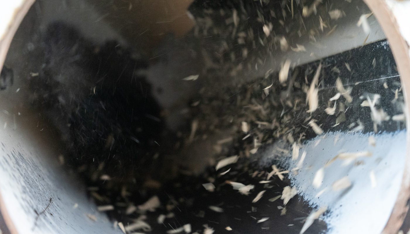 Wood chips swirling inside a cylindrical chute.