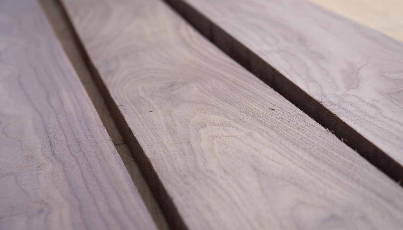 Close-up of weathered wooden planks laid parallel with narrow gaps, showcasing natural wood grain and subtle color variation.