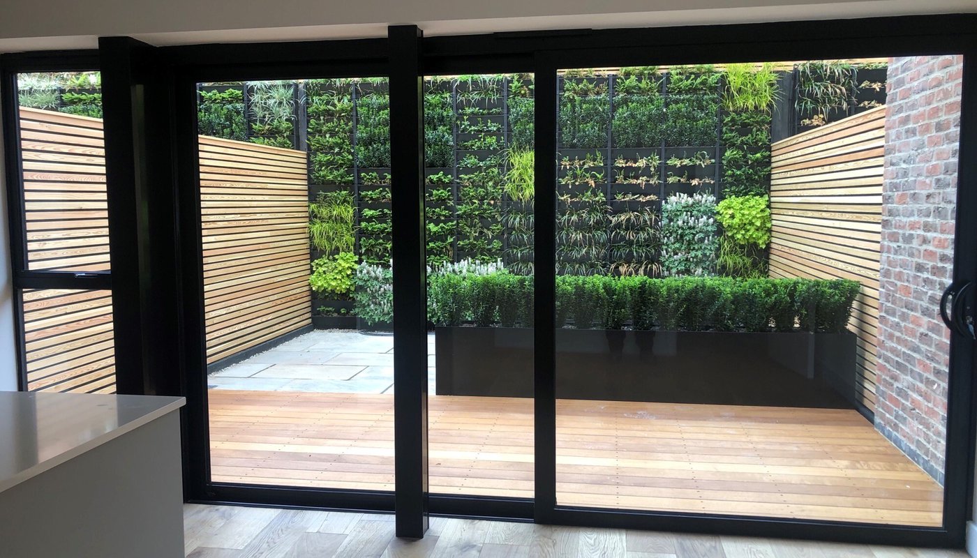 A small garden with Iroko decking and Siberian Larch slatted fencing.