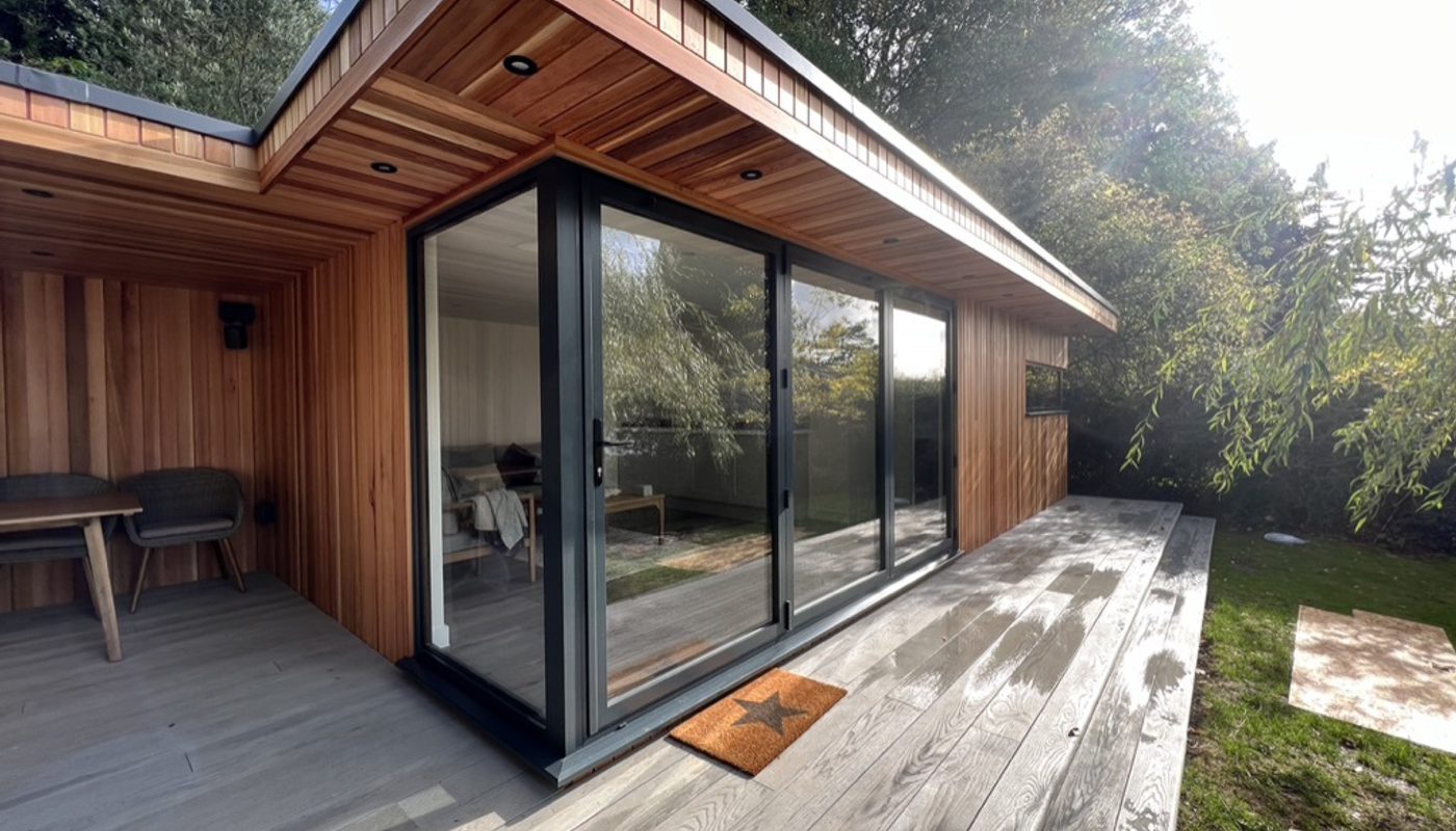 A garden room with large bifold doors, clad stylishly in western red cedar cladding.