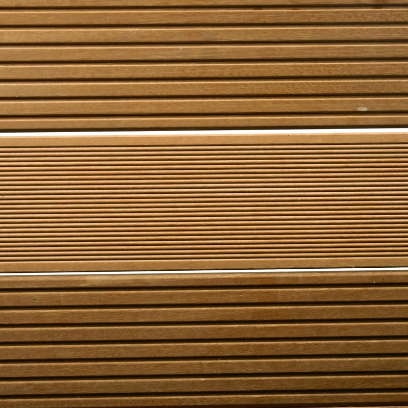 Close-up of evenly spaced horizontal brown wooden slats with thin light dividers, creating a uniform shutter-like wall pattern.