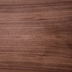 Close-up of a brown wood grain surface with subtle horizontal patterns, resembling a wooden tabletop.