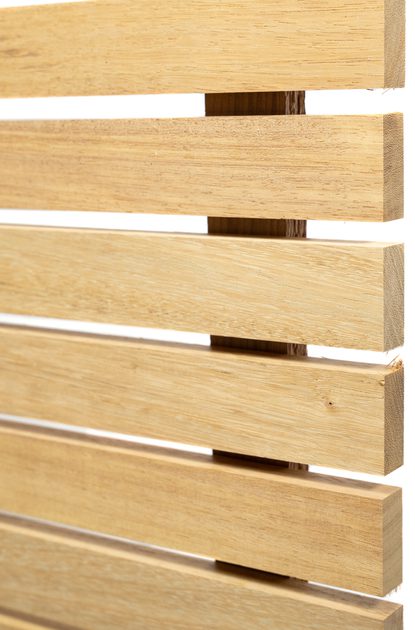 Close-up of light wooden slats arranged horizontally with small gaps, forming a slatted screen.