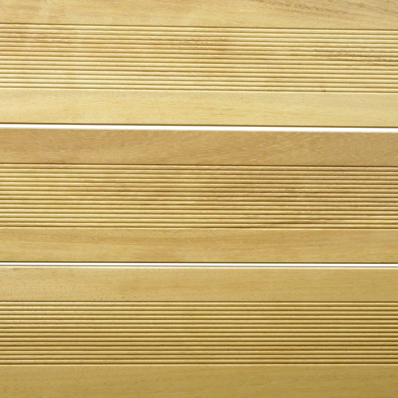 Close-up of light wood planks with evenly spaced horizontal grooves and thin white gaps between boards.