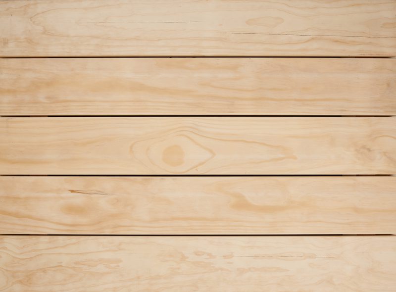 Horizontal light beige wooden planks with visible grain patterns and seams, forming a smooth natural wood surface.