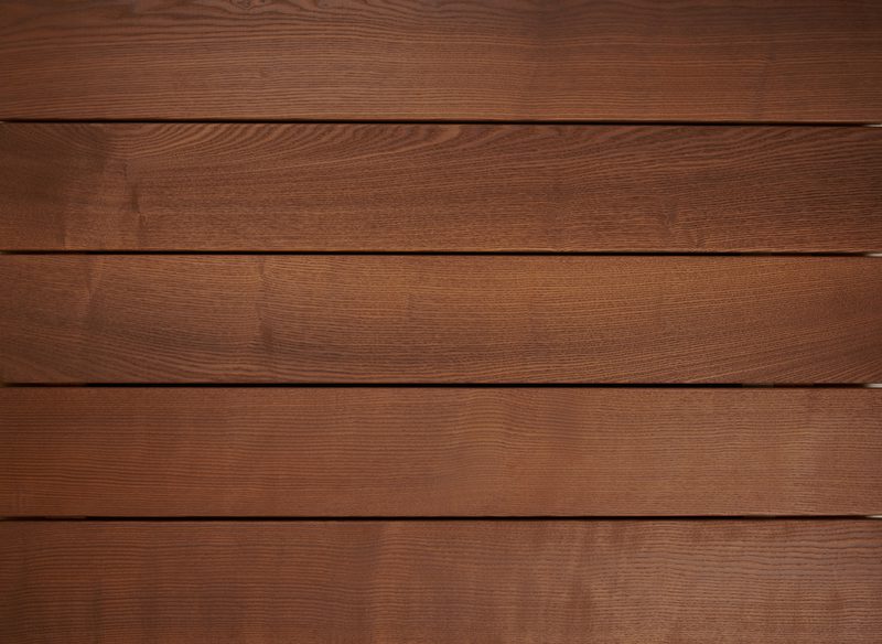 Close-up of horizontal brown wooden planks with visible grain and narrow gaps between boards.