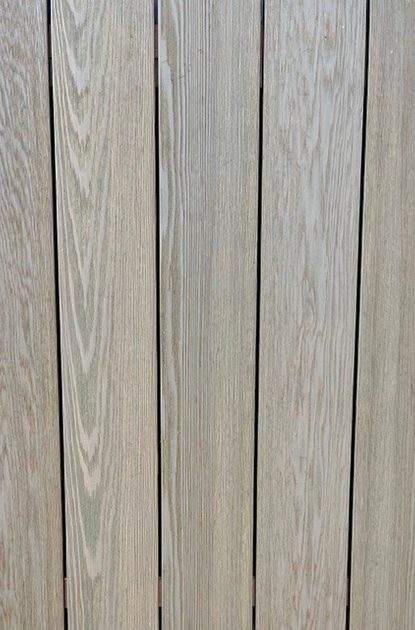Close-up of vertical light wood planks with distinct grain patterns and narrow dark gaps.