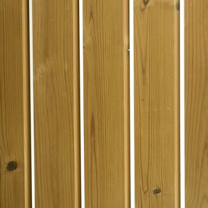 Close-up of vertical brown wooden planks with visible grain and knots, separated by thin white gaps.