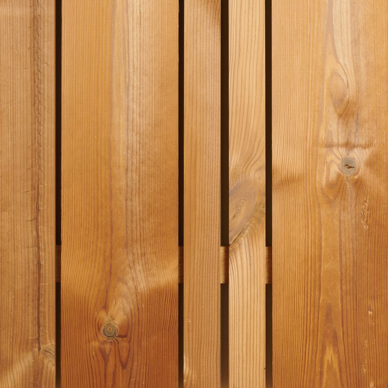 Close-up of vertical wooden planks with narrow gaps, warm brown tones, and visible grain patterns and knots.