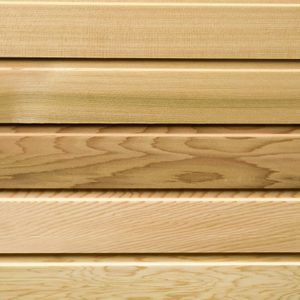 Stack of light-colored wooden planks with visible grain patterns, arranged in horizontal layers.
