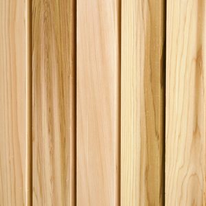 Close-up of vertical wooden planks in light beige tones, showing natural grain patterns and narrow gaps between boards.