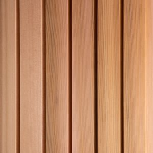 Close-up of vertical wooden planks in warm brown tones, with visible wood grain and narrow gaps.