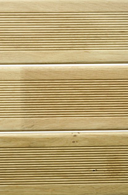 Close-up of light beige wooden planks with evenly spaced narrow grooves and visible wood grain.