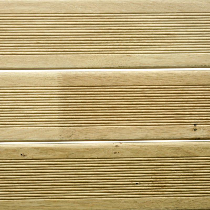 Close-up of light beige wooden planks with evenly spaced narrow grooves and visible wood grain.