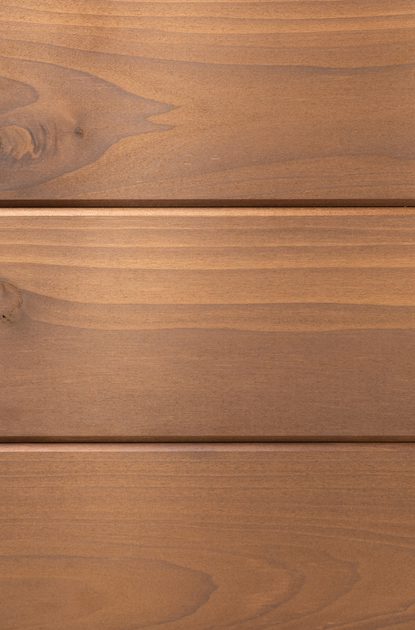 A close-up of warm brown wooden planks with visible grain and knots, arranged horizontally with small gaps between boards.