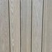 Vertical wooden boards with light weathered grain, evenly spaced with narrow gaps.