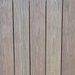 Vertical wooden planks with visible grain and small gaps; weathered gray-brown deck or fence surface.